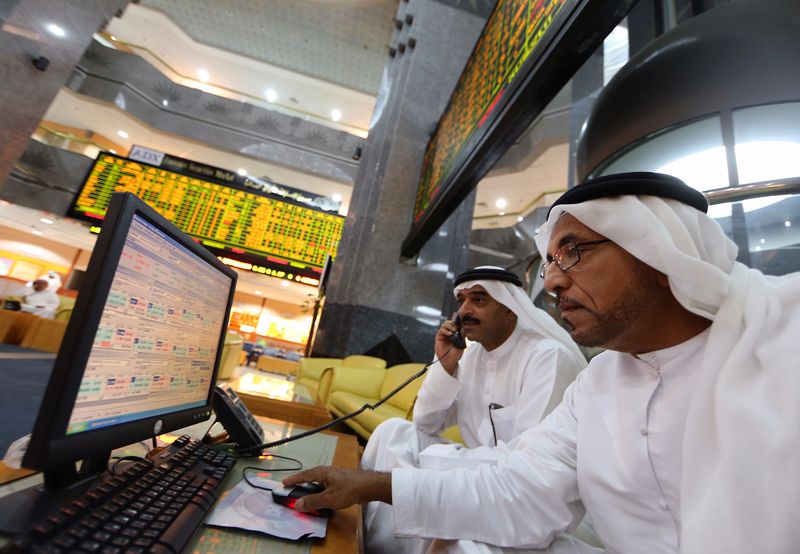 &copy; Reuters. مستثمرون يتابعون شاشات تعرض بيانات عن مؤشرات الأسهم في بورصة أبوظبي - صورة من أرشيف رويترز.