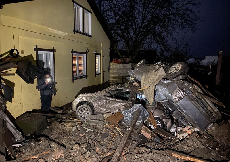 &copy; Reuters. FOTO DE ARCHIVO. Un hombre junto a automóviles destruidos por un ataque con misiles rusos, en medio del ataque de Rusia a Ucrania, en una zona residencial de Járkov. 8 de diciembre de 2022. REUTERS/Vitalii Hnidyi