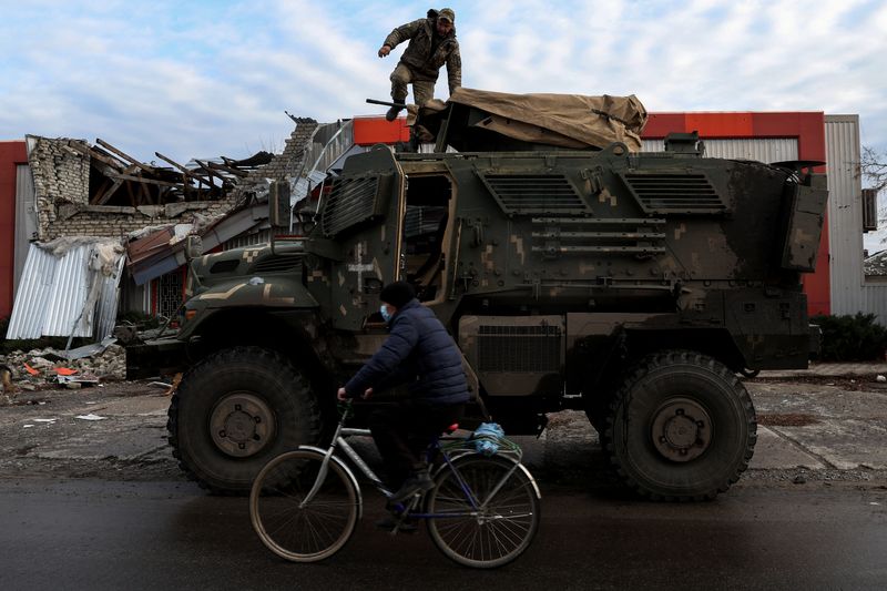 &copy; Reuters. Un hombre en pasa en bicicleta frente a un soldado sobre un vehículo militar MaxxPro de fabricación estadounidense en la ciudad de Lyman, región de Donetsk, Ucrania, el 11 de diciembre de 2022. REUTERS/Shannon Stapleton