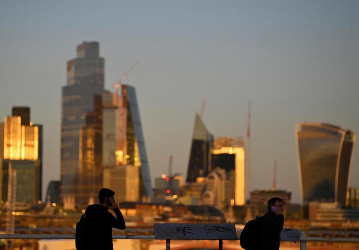 © Reuters. People cross Waterloo Bridge during the evening rush-hour with skyscrapers of the City of London financial district seen behind in London, Britain, October 10, 2022.  REUTERS/Toby Melville