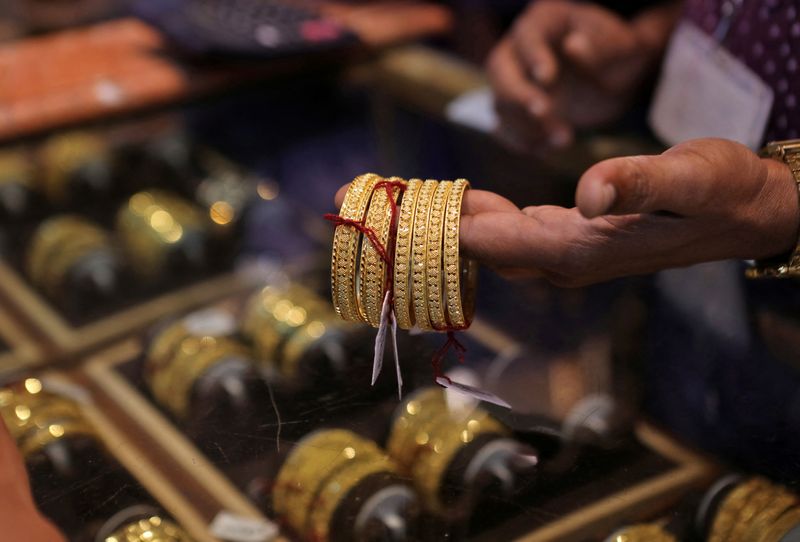 &copy; Reuters. FOTO DE ARCHIVO: Un vendedor muestra brazaletes de oro a un cliente en una sala de exposición de joyas durante Dhanteras, un festival hindú asociado con Lakshmi, la diosa de la riqueza, en Mumbai, India. 22 de octubre, 2022. REUTERS/Niharika Kulkarni/Ar