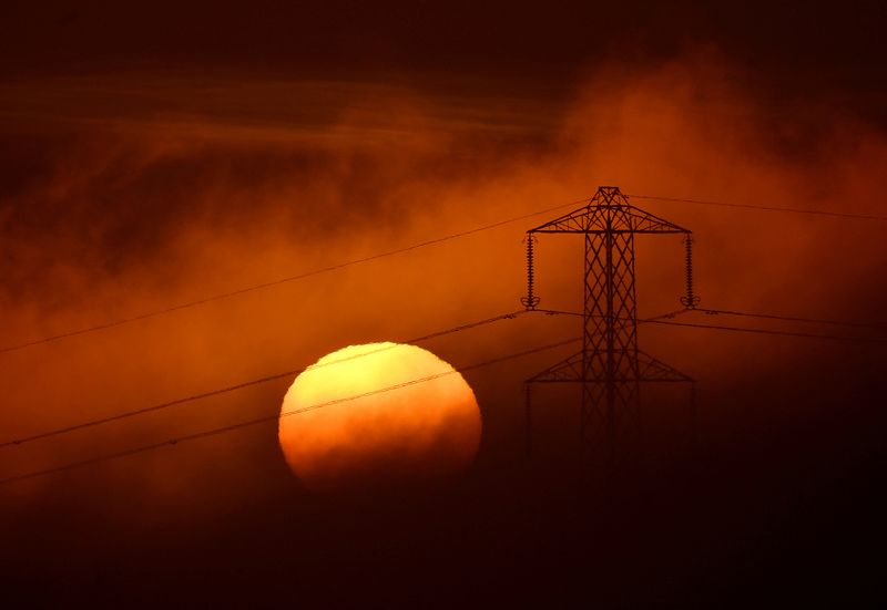 &copy; Reuters. Le soleil se couche derrière un pylône électrique près de Petersfield, en Grande-Bretagne. /Photo prise le 1er décembre 2022/REUTERS/Toby Melville
