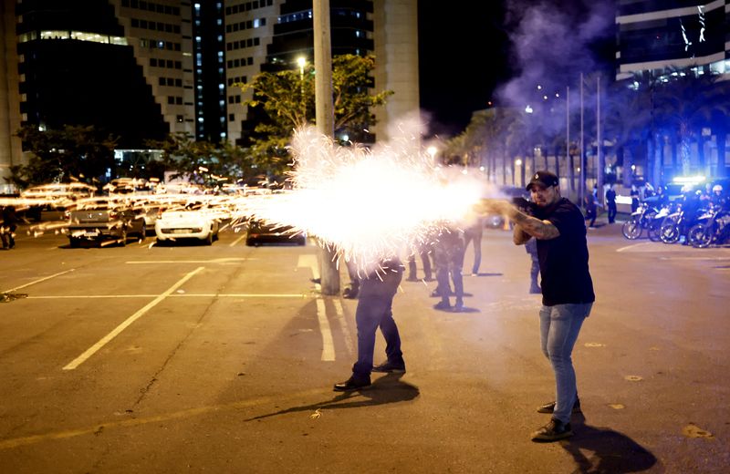 &copy; Reuters. A police officer fires a shotgun as supporters of Brazilian President Jair Bolsonaro protest in Brasilia, Brazil, December 12, 2022.  REUTERS/Ueslei Marcelino