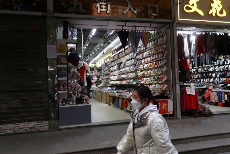 &copy; Reuters. امرأة تمر أمام محال تجارية بعد تخفيف الحكومة الصينية من قيود مكافحة انتشار فيروس كورونا في مدينة ووهان يوم العاشر من ديسمبر كانون الأول 2022. 