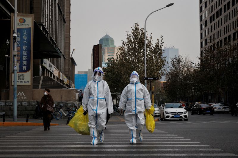 &copy; Reuters. FILE PHOTO: Pandemic prevention workers in protective suits cross a street as coronavirus disease (COVID-19) outbreaks continue in Beijing, December 9, 2022. REUTERS/Thomas Peter/File Photo