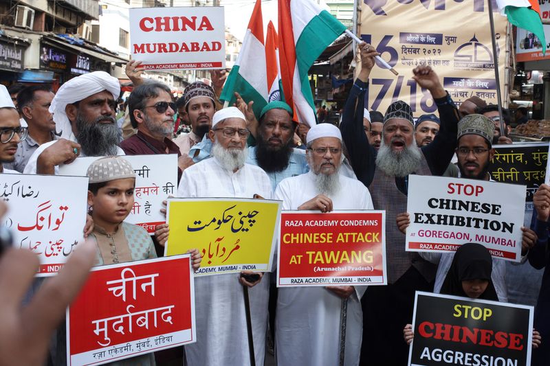 © Reuters. Demonstrators hold signs during a protest against China, following a border scuffle at the Tawang sector of India's northeastern Himalayan state of Arunachal Pradesh that led to injuries to soldiers on both sides, in Mumbai, India, December 13, 2022. REUTERS/Francis Mascarenhas