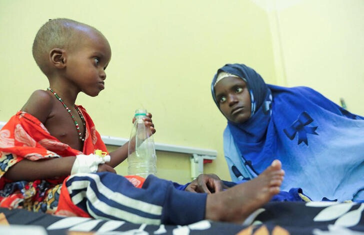&copy; Reuters. Imagen de archivo de una niña malnutrida de tres años bebiendo agua de una botella mientras su madre mira en la sección de pediatría del Hospital Banadir de Mogadiscio, Somalia. 24 septiembre 2022. REUTERS/Feisal Omar