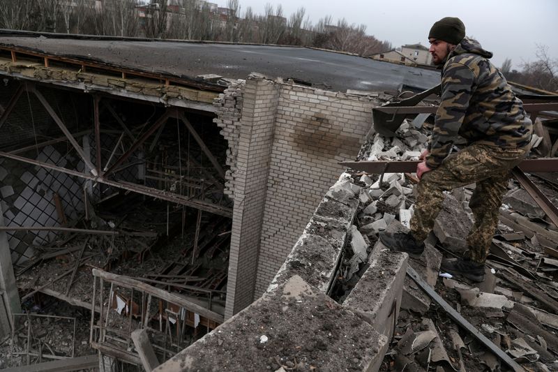 © Reuters. جندي أوكراني يقف على سقف مبنى تعرض لدمار بفعل ضربات صاروخية على كراماتورسك يوم الثلاثاء. تصوير: شانون ستابلتون - رويترز. 