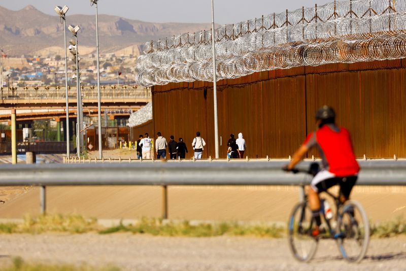 &copy; Reuters. FILE PHOTO: Asylum-seeking migrants, mostly from Venezuela, walk near the border wall after crossing the Rio Bravo river to turn themselves in to U.S. Border Patrol agents to request asylum in El Paso, Texas, U.S., as seen from Ciudad Juarez, Mexico, Sept