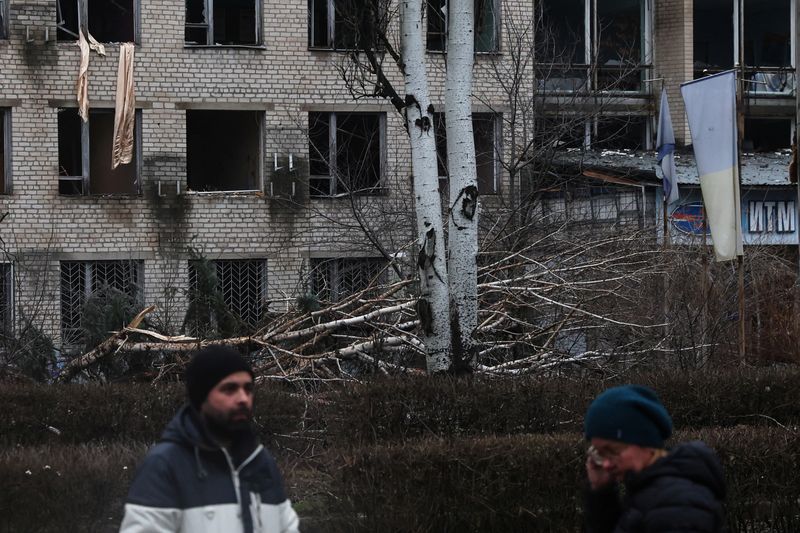 &copy; Reuters. FOTO DE ARCHIVO. Personas permanecen frente a una universidad dañada por un reciente ataque con misiles en Kramatorsk, Ucrania. 13 de diciembre de 2022. REUTERS/Shannon Stapleton