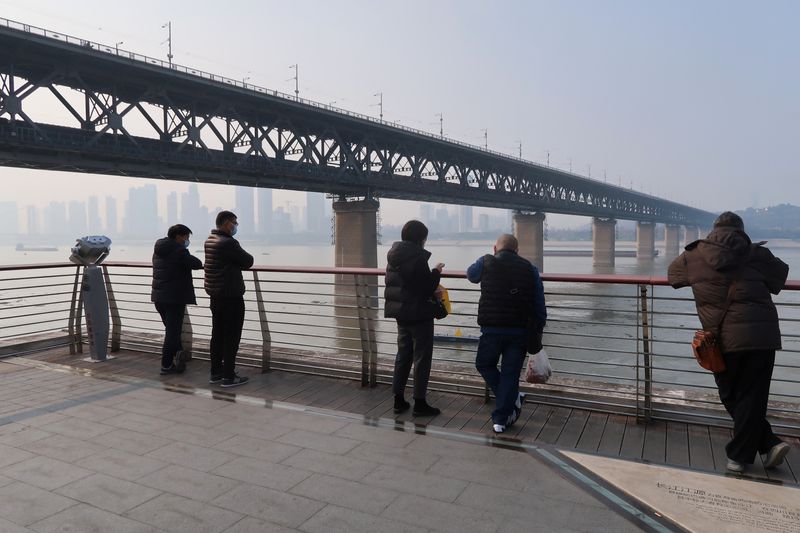&copy; Reuters. FILE PHOTO: People stand by a river, after the government eased curbs on the coronavirus disease (COVID-19) control, in Wuhan, Hubei province, China December 10, 2022. REUTERS/Martin Pollard