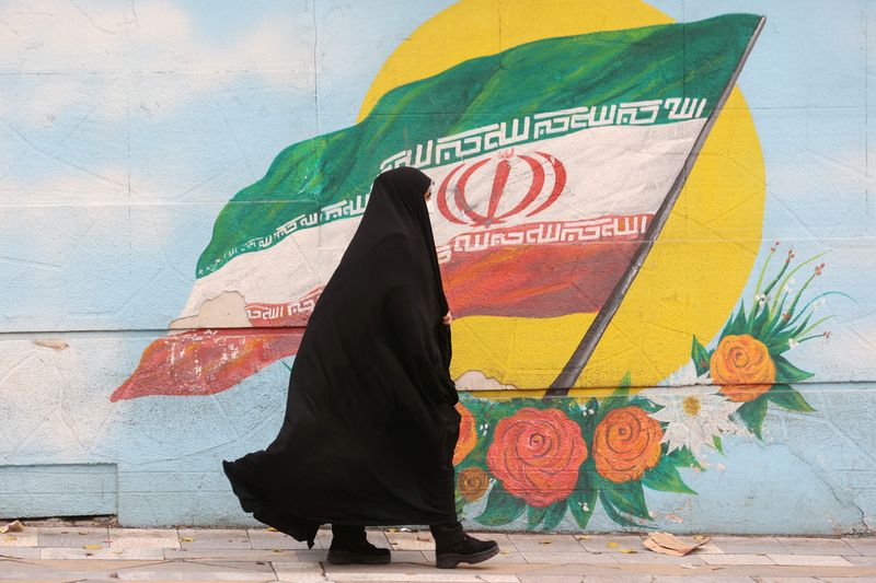 &copy; Reuters. Mulher caminha em Terrã ante grafite com bandeira do Irã
06/12/2022
Majid Asgaripour/WANA (West Asia News Agency) via REUTERS