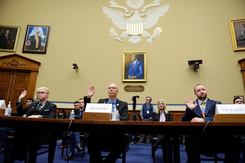 © Reuters. Michael Anderson, survivor of Club Q shooting, Matthew Haynes, founding owner of Club Q and James Slaugh, survivor of Club Q shooting take the oath during a House Committee on Oversight and Reform Hearing on 