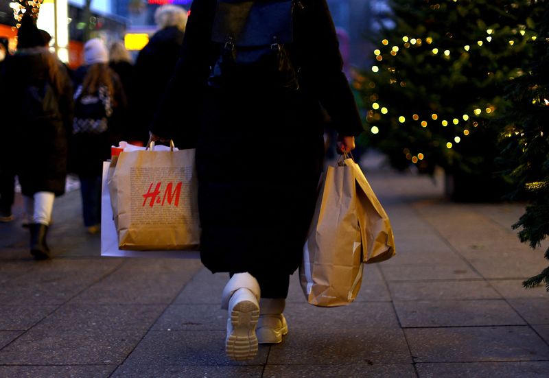 &copy; Reuters. A woman carries a shopping bag branded with the fashion chain H&M as she walks along Kurfuerstendamm shopping street looking for bargains on the second weekend of advent in Berlin, Germany, December 3, 2022. REUTERS/Lisi Niesner/Files