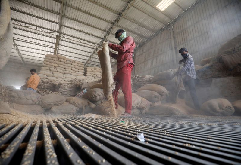 &copy; Reuters. Workers empty wheat sacks for sifting at a grain mill on the outskirts of Ahmedabad, India, May 16, 2022. REUTERS/Amit Dave/Files