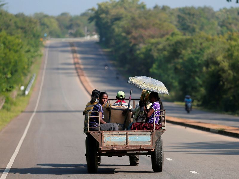 &copy; Reuters. FILE PHOTO: Villagers travel in a tractor on a newly built road in Hambantota, Sri Lanka March 24, 2019. REUTERS/Dinuka Liyanawatte