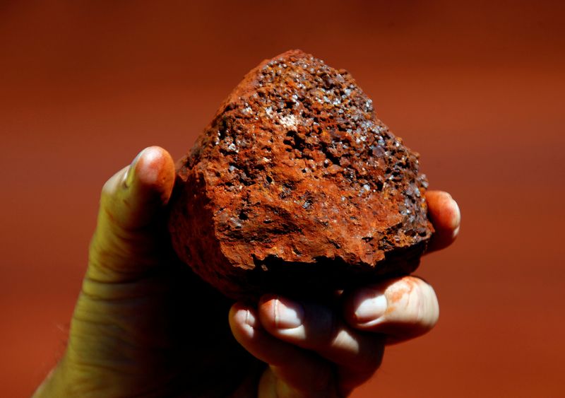 &copy; Reuters. FILE PHOTO: A miner holds a lump of iron ore at a mine located in the Pilbara region of Western Australia December 2, 2013. REUTERS/David Gray/File Photo