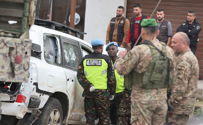 © Reuters. Lebanese army members and the United Nations peacekeepers (UNIFIL) stand near of what witnesses stated to be the UNIFIL vehicle that was carrying the Irish soldier who was killed on a U.N. peacekeeping Patrol, in Al-Aqbieh, south Lebanon December 15, 2022. REUTERS/Aziz Taher