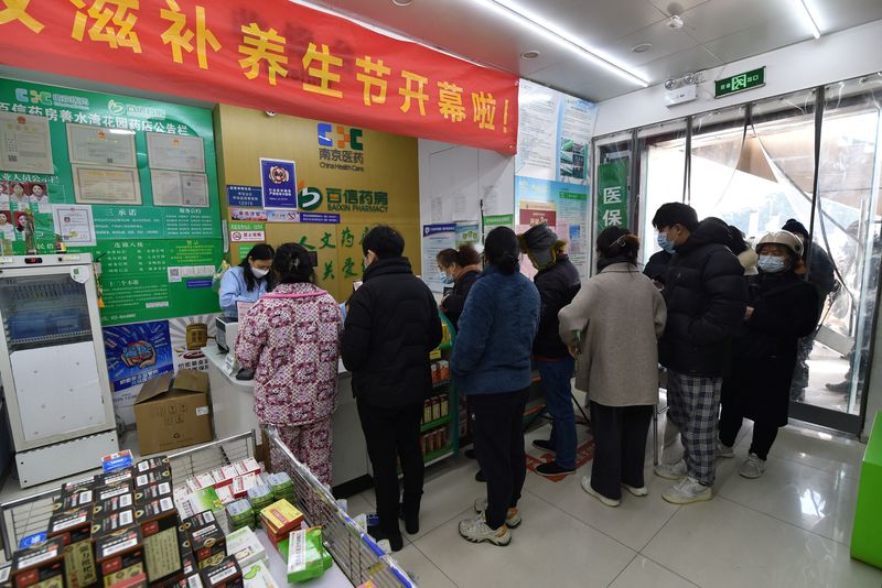 &copy; Reuters. Varios residentes hacen cola en una farmacia para comprar kits de pruebas de antígenos para el COVID-19, en Nanjing, provincia de Jiangsu, China, 15 de diciembre 2022. REUTERS/China Daily