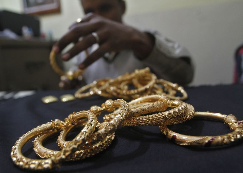 &copy; Reuters. FOTO DE ARCHIVO: Un orfebre sostiene brazaletes de oro terminados en un taller en Calcuta, India. 16 de enero, 2013. REUTERS/Rupak De Chowdhuri/Archivo