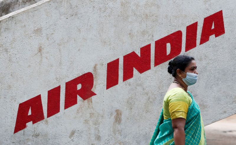 © Reuters. FILE PHOTO: A woman walks past Air India airlines branding in Mumbai, India, October 19, 2021. REUTERS/Francis Mascarenhas/File Photo