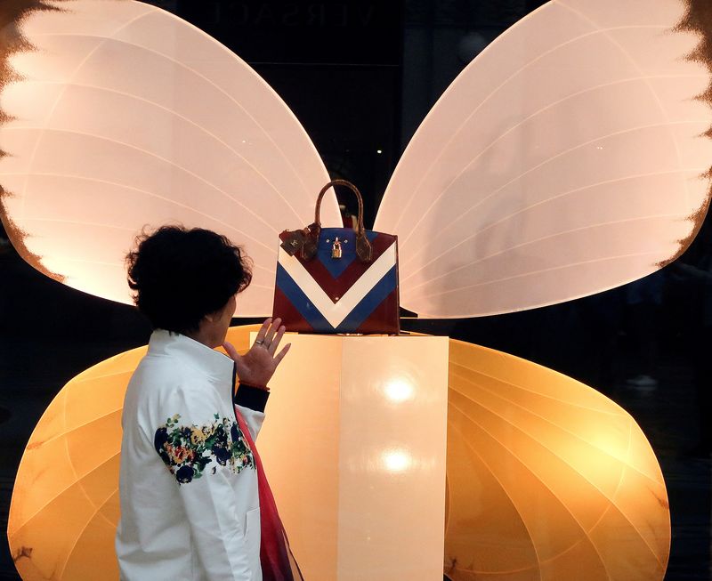 © Reuters. FILE PHOTO: A woman looks at a Louis Vuitton fashion bag outside the flagship store in downtown in Milan, Italy, October 18, 2018.    REUTERS/Stefano Rellandini/File Photo