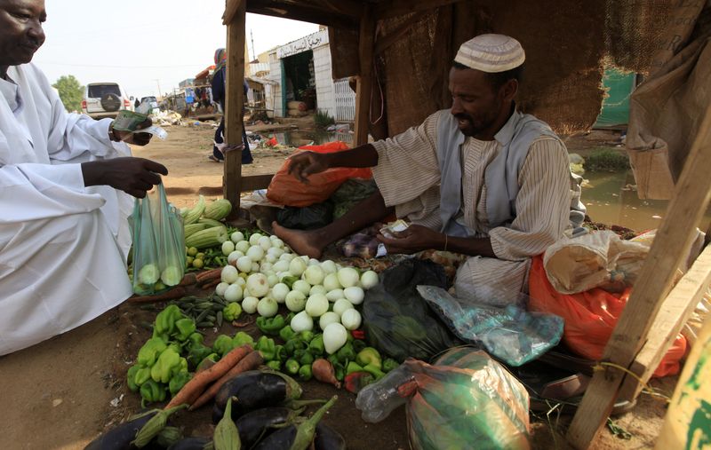© Reuters. بائع يبيع الخضروات في الخرطوم بصورة من أرشيف رويترز.