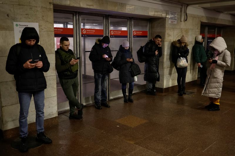 &copy; Reuters. أشخاص يستخدمون هواتفهم بجوار محطة مترو في كييف يوم الجمعة. تصوير: فالنتين أوجيرينكو - رويترز.