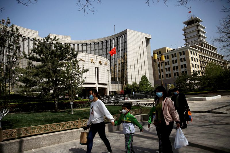 &copy; Reuters. FILE PHOTO: People walk past the headquarters of Chinese central bank People's Bank of China (PBOC), April 4, 2020. REUTERS/Tingshu Wang