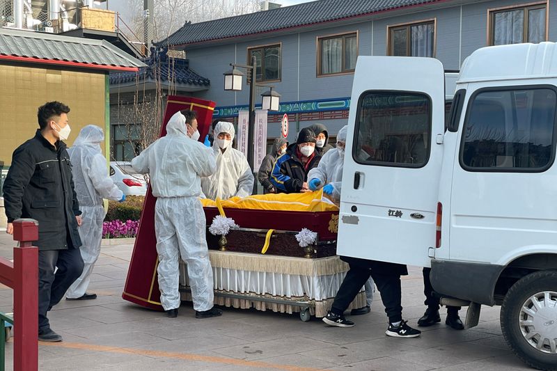 &copy; Reuters. Trabajadores con trajes protectores trasladan un cuerpo en un ataúd en una funeraria, en medio del brote de la enfermedad por coronavirus (COVID-19) en Pekín, China. 17 de diciembre de 2022. REUTERS/Alessandro Diviggiano