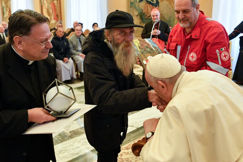 &copy; Reuters. البابا فرنسيس بابا الفاتيكان يقبل يد رجل مشرد منحه جائزة الأم تريزا خلال الاحتفال بعيد ميلاده السادس والثمانين في الفاتيكان يوم السبت. صورة
