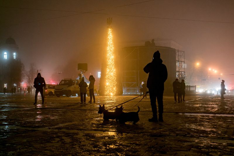 &copy; Reuters. مجموعة من الأشخاص يسيرون بجوار شجرة عيد الميلاد وسط ضباب كثيف بميدان سوفيسكا بالعاصمة الأوكرانية كييف يوم السبت . تصوير :  فلاديسلاف موسيينك
