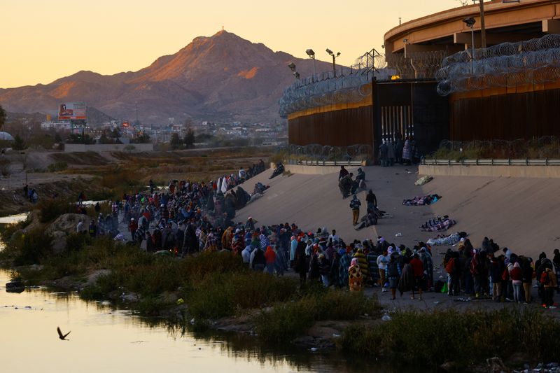 &copy; Reuters. FOTO DE ARCHIVO-Migrantes hacen fila cerca del muro fronterizo después de cruzar el río Bravo para entregarse a agentes de la Patrulla Fronteriza de Estados Unidos y solicitar asilo en la ciudad estadounidense de El Paso, Texas, imagen vista desde Ciuda