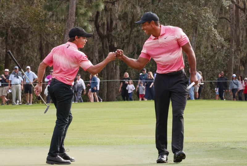 &copy; Reuters. 　プロが家族とペアで争うゴルフのエキシビション大会、ＰＮＣ選手権が１７日、米フロリダ州オーランドのリッツカールトンＧＣ（パー７２）で開幕。タイガー・ウッズ（右）が１３歳の
