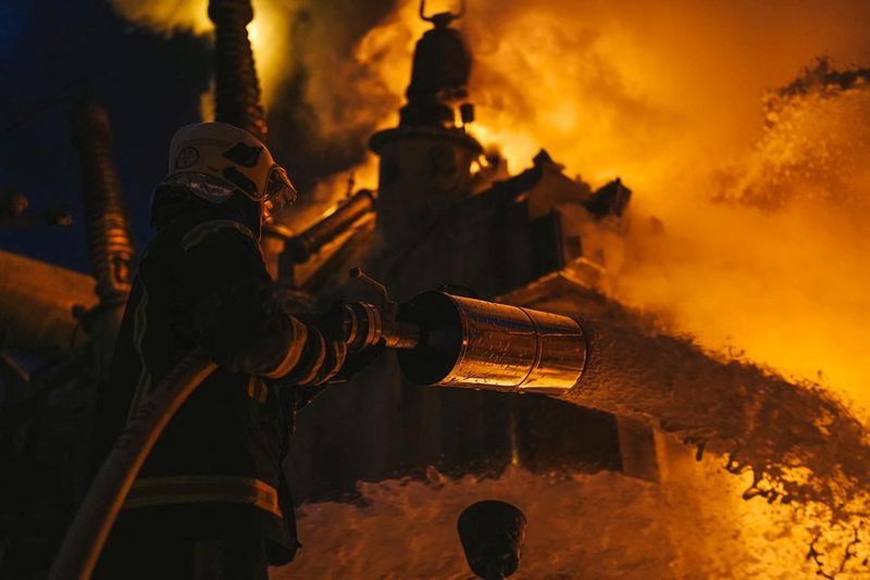 © Reuters. Firefighters work at a site of a critical power infrastructure object, which was hit during Russia's drones attacks in Kyiv, Ukraine, in this handout picture released December 19, 2022. Press service of the State Emergency Service of Ukraine/Handout via REUTERS 