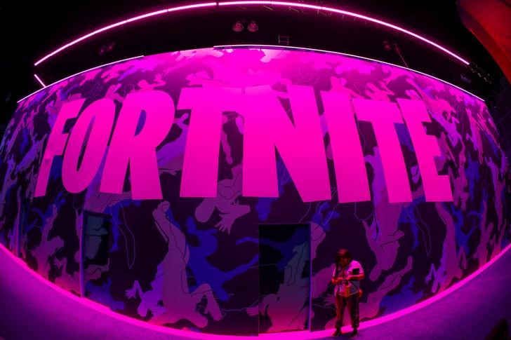 &copy; Reuters. Imagem de arquivo de pessoa ao lado de pôster do game "Fortnite", da Epic Games, na exposição anual E3 em Los Angeles, Califórnia, EUA. 12/06/2019. REUTERS/Mike Blake