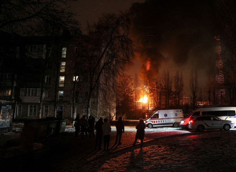 &copy; Reuters. Local residents gather near a residential building as a critical power infrastructure object burns after a Russian drone attack, amid Russia's attack on Ukraine, in Kyiv, Ukraine December 19, 2022. REUTERS/Gleb Garanich