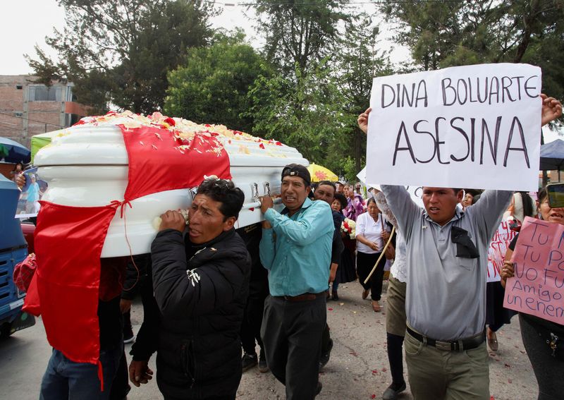 &copy; Reuters. Relatives and friends carry the coffin with the body of Leonardo Hancco Chacca, 32, who was killed in a clash between security forces and protesters, during his funeral along the streets in Ayacucho, Peru December 18, 2022. The sign reads "Dina Boluarte m