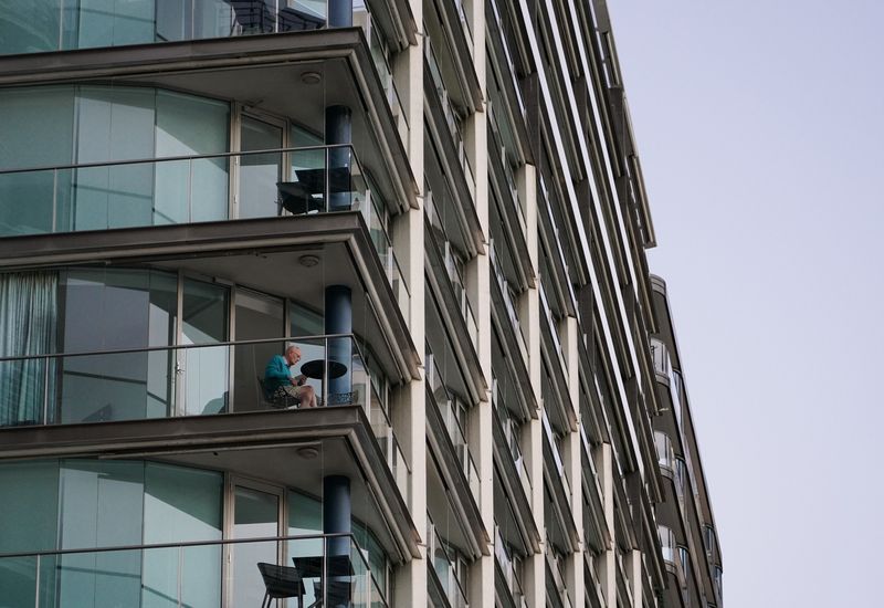 &copy; Reuters. FILE PHOTO: A lone man sits on an apartment building balcony at Circular Quay during a lockdown to curb the spread of a coronavirus disease (COVID-19) outbreak in Sydney, Australia, July 15, 2021.  REUTERS/Loren Elliott