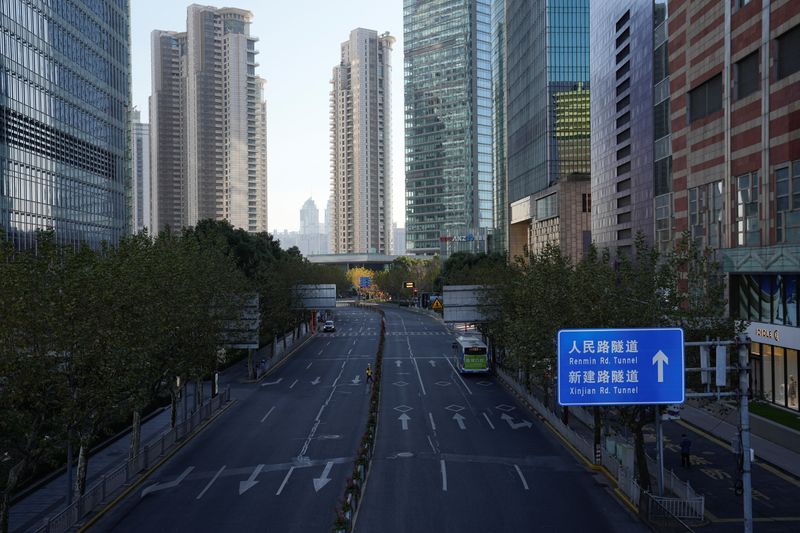 © Reuters. A delivery worker crosses an empty road in Lujiazui financial district, as coronavirus disease (COVID-19) outbreaks continue in Shanghai, China, December 19, 2022. REUTERS/Aly Song
