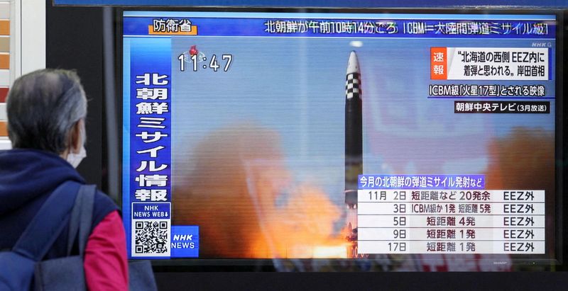 &copy; Reuters. FOTO DE ARCHIVO. Un transeúnte mira una pantalla de televisión en Tokio, Japón, que muestra una noticia sobre Corea del Norte disparando un misil balístico. 18 de noviembre de 2022. Crédito obligatorio Kyodo vía REUTERS