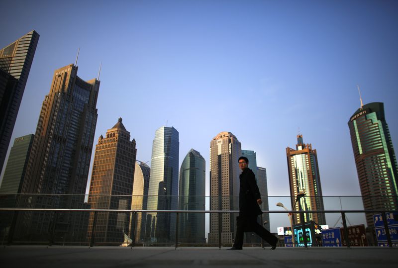 &copy; Reuters. Photo d'archive :  Un homme marche dans le quartier financier de Pudong à Shanghai. /Photo prise le 11 mars 2014/REUTERS/Carlos Barria