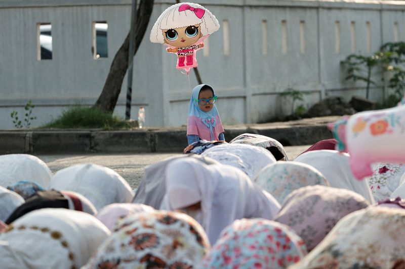 &copy; Reuters. FILE PHOTO: Muslim girl holds a balloon while attending mass prayers at the Sunda Kelapa port during Eid al-Fitr, marking the end of the holy fasting month of Ramadan, in Jakarta, Indonesia, May 2, 2022. REUTERS/Willy Kurniawan/File Photo