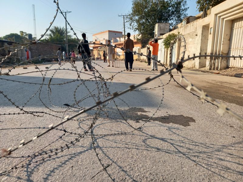 &copy; Reuters. Residentes juegan al críquet en una calle sellada con alambre de espino en Bannu, Pakistán. 20 de diciembre de 2022. REUTERS/Zahid Muhammad