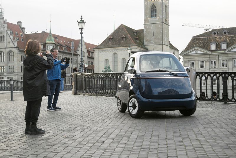 &copy; Reuters. FILE PHOTO: People take pictures of an an electric-powered Microlino 2.0 car of Swiss manufacturer Microlino AG in Zurich, Switzerland November 21, 2022.  REUTERS/Arnd Wiegmann