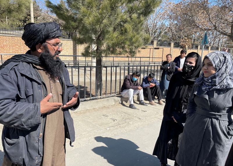 &copy; Reuters. Foto de archivo de un talibán hablando con dos estudiantes en una universidad en Kabul.
Feb 26, 2022. REUTERS/Stringer/ 