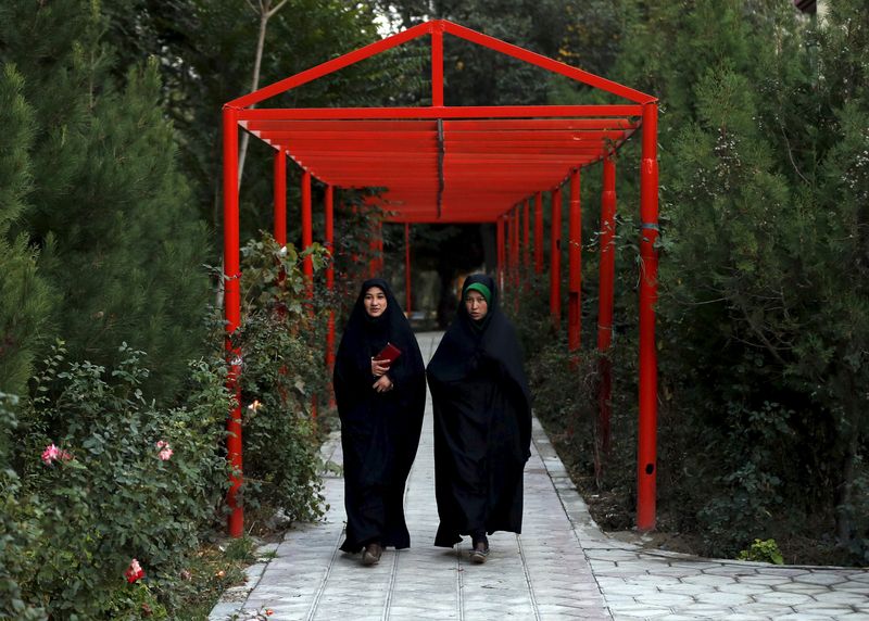 © Reuters. سيدتان أفغانيتان تسيران داخل حرم جامعة كابول في صورة من أرشيف رويترز .  