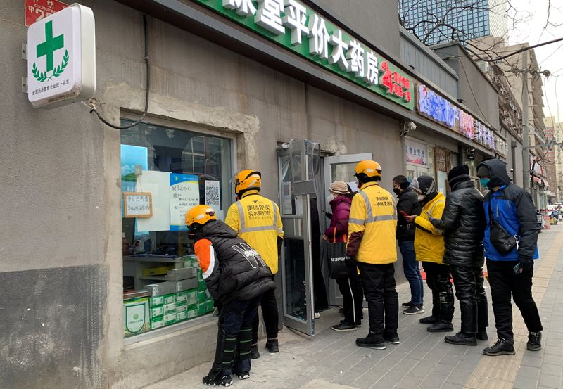 &copy; Reuters. Delivery workers wait outside a pharmacy to pick up orders as coronavirus disease (COVID-19) outbreaks continue in Beijing, December 20, 2022. REUTERS/Xiaoyu Yin