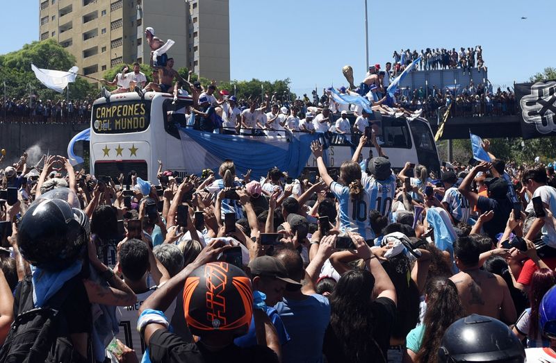 © Reuters. المشجعون الأرجنتينيون في شوارع بوينس أيرس يوم الثلاثاء يحيون لاعبي منتخب الأرجنتين لدى عودتهم إلى البلاد بعد فوزهم بكأس العالم لكرة القدم 2022.  تصوير : مارتين فيلار- رويترز. (يحظر إعادة بيع الصورة أو وضعها في الأرشيف) .  
 