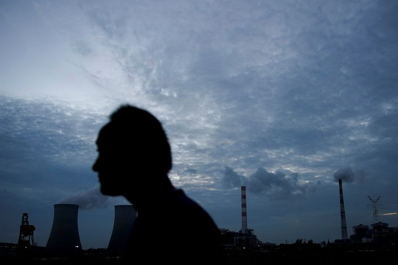 &copy; Reuters. FILE PHOTO: A man walks past a coal-fired power plant in Shanghai, China, October 14, 2021. REUTERS/Aly Song/File Photo